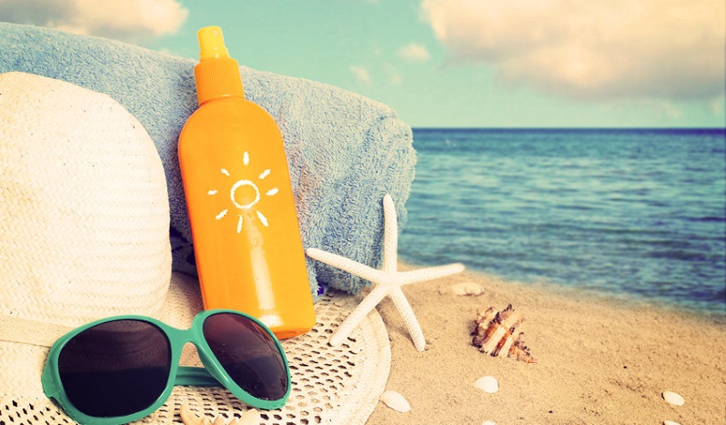 A bottle of sunscreen on the beach as a metaphor for Basal cell carcinoma, skin cancer and skin lesions 